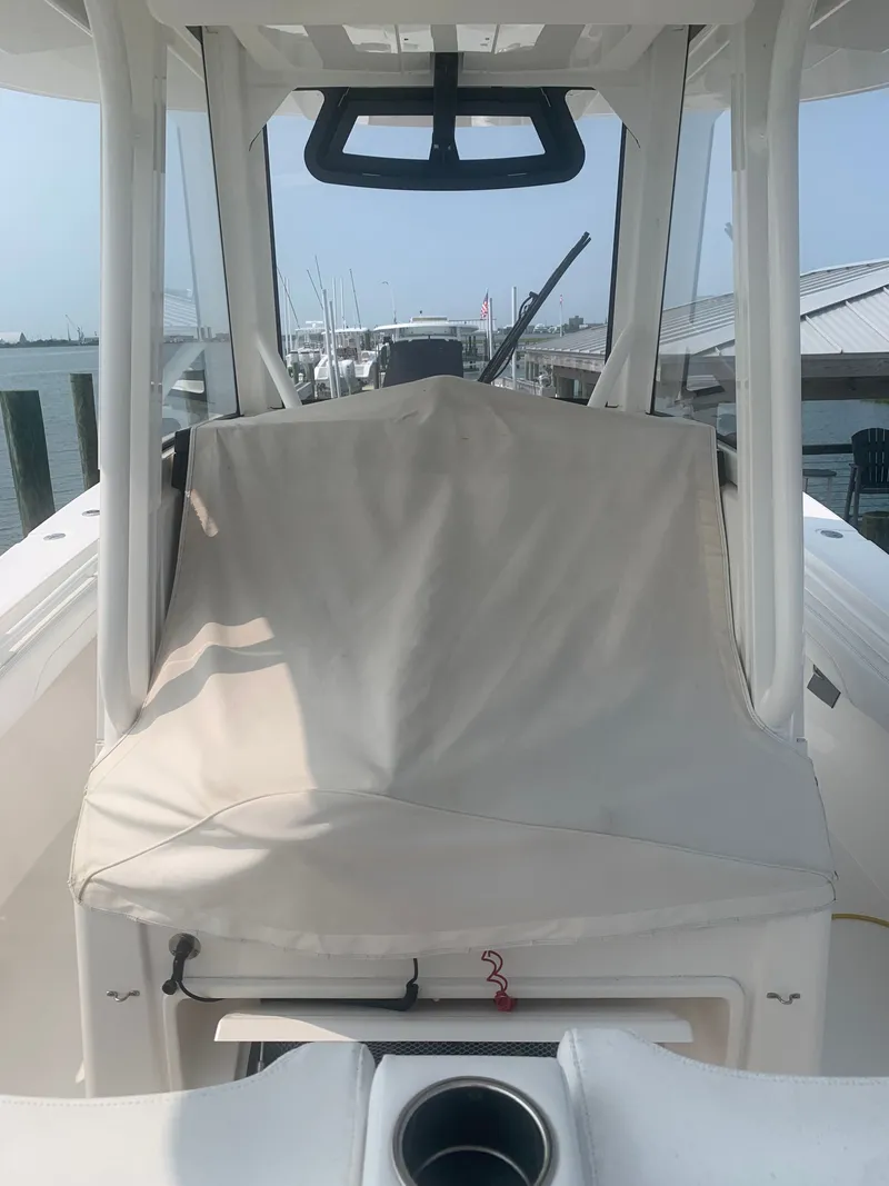 Slide: The Image of A 2020 Regulator 31 boat with a covered helm station, docked at a marina. - 57