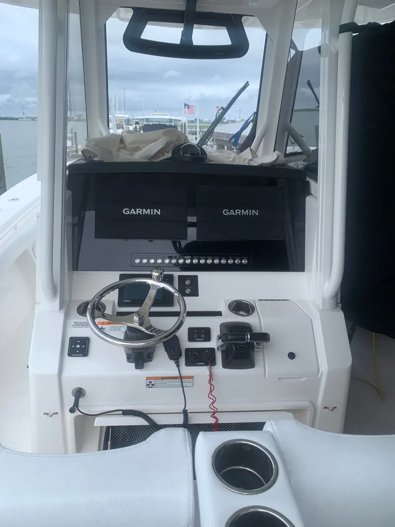 Slide: The Image of The image shows the helm of a 2020 Regulator 31 boat with Garmin screens. - 8