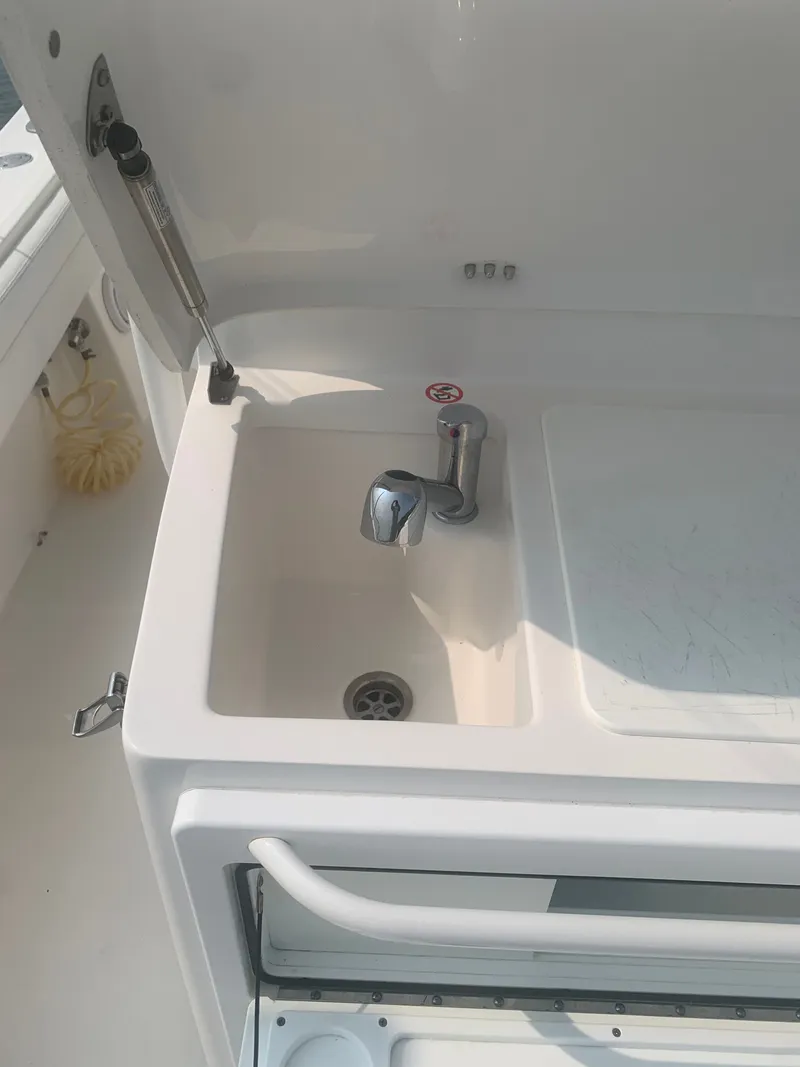 Slide: The Image of A sink with a faucet on a boat, surrounded by white casing. - 32