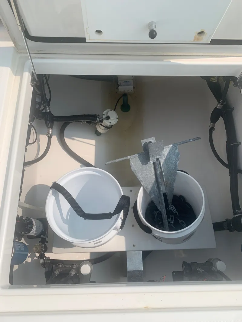 Slide: The Image of An open storage compartment on a 2020 Regulator 31 boat with buckets and an anchor. - 28