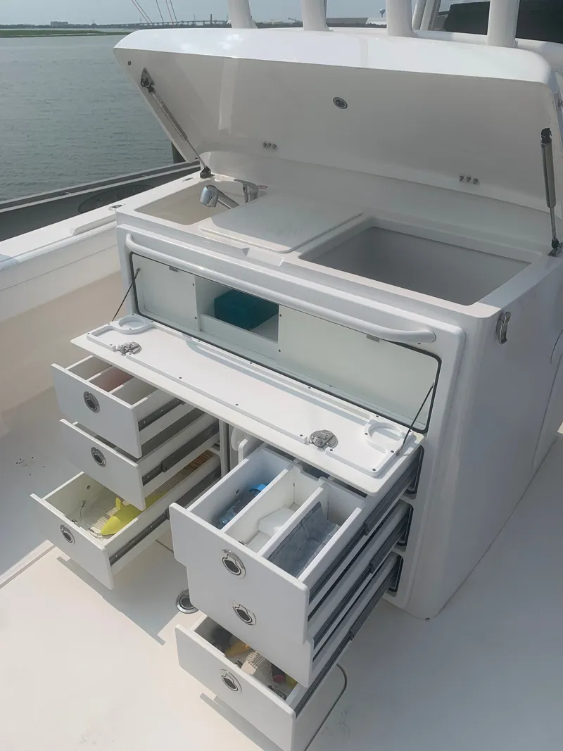 Slide: The Image of 2020 Regulator 31 with open storage compartments and drawers on a boat. - 34