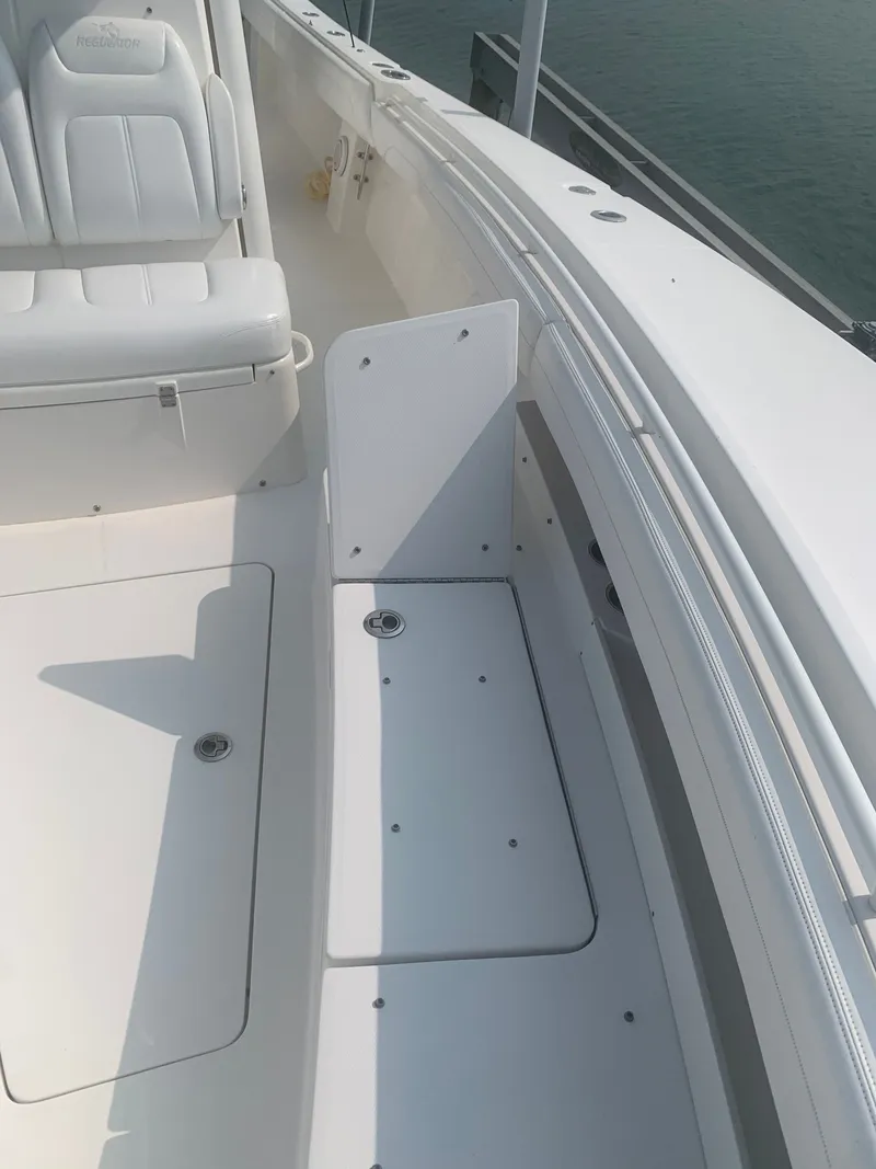 Slide: The Image of The image shows the deck of a 2020 Regulator 31 boat with white upholstery and storage. - 21