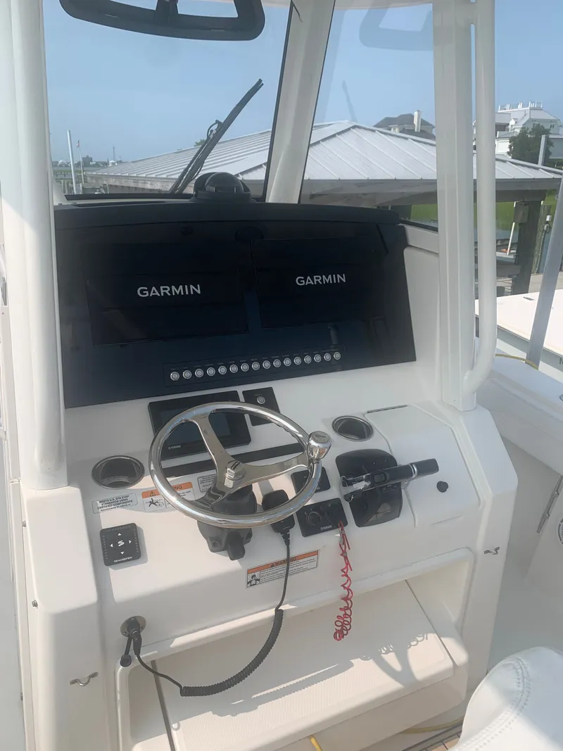 Slide: The Image of The image shows the helm of a 2020 Regulator 31 boat with Garmin screens. - 27