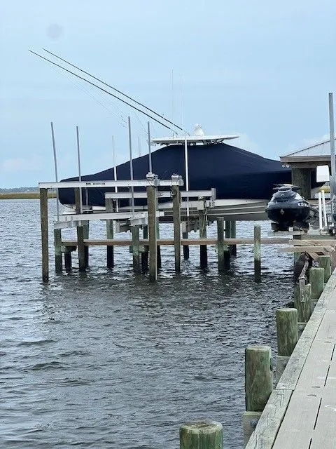 Slide: The Image of A 2020 Regulator 31 boat is docked at a wooden pier, covered with a blue tarp. - 26