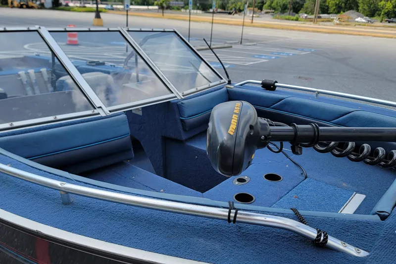 Slide: The Image of 1988 BLUE FINN SPORTSMAN 1700 boat interior with blue seating and windshield in parking lot. - 7