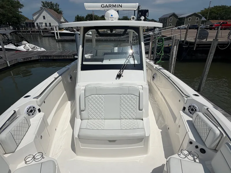 Slide: The Image of The image shows a modern boat with white upholstery and a Garmin navigation system, docked at a pier. - 24