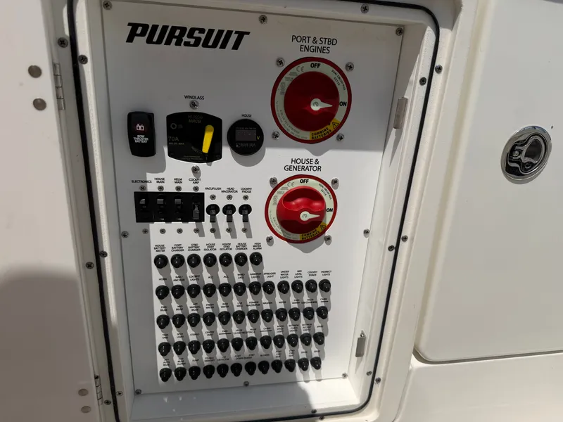 Slide: The Image of Control panel of a Pursuit S 328 Sport boat with toggle switches and red rotary knobs. - 28