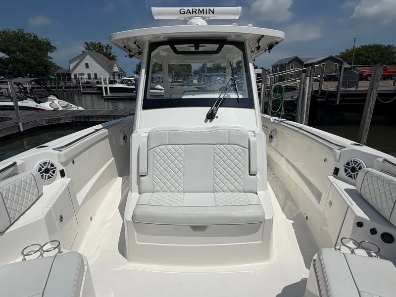 Slide: The Image of The image shows the cockpit of a 2025 Pursuit S 328 Sport boat with white upholstery. - 25