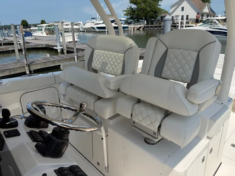 Slide: The Image of Two luxurious, cushioned seats with armrests on a boat, surrounded by a marina. - 15