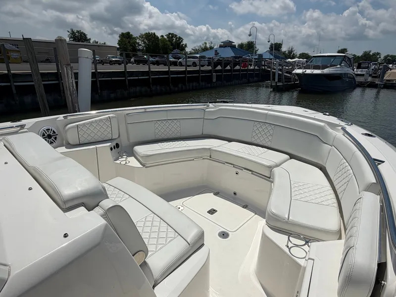 Slide: The Image of The image shows the spacious cockpit of a Pursuit S 328 Sport boat with white upholstery. - 21
