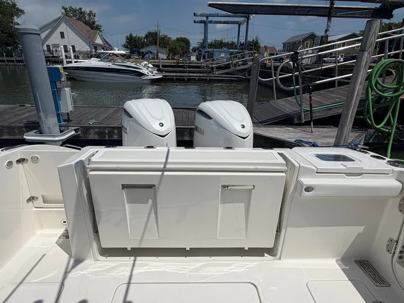 Slide: The Image of The image shows the stern of a Pursuit S 328 Sport boat at a dock. Two engines are visible. - 8