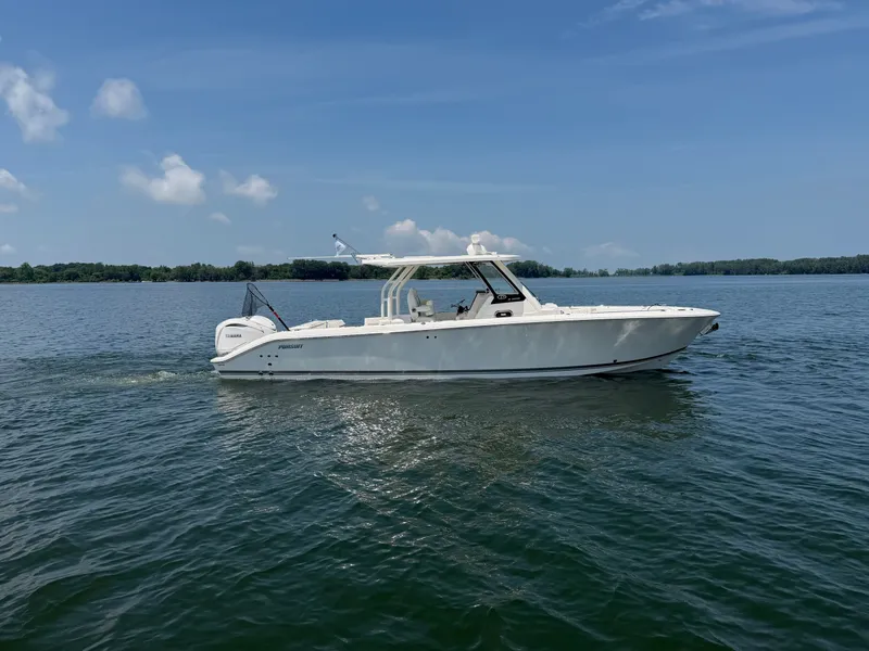 Slide: The Image of A white Pursuit S 328 Sport boat from 2025 cruises on calm water under a blue sky. - 1