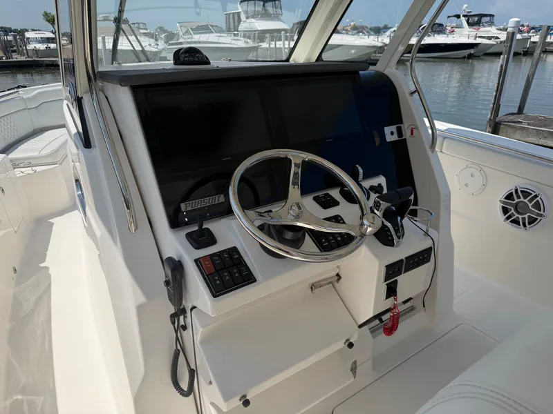 Slide: The Image of The image shows the helm of a 2025 Pursuit S 328 Sport with a sleek steering wheel and modern instruments. - 14