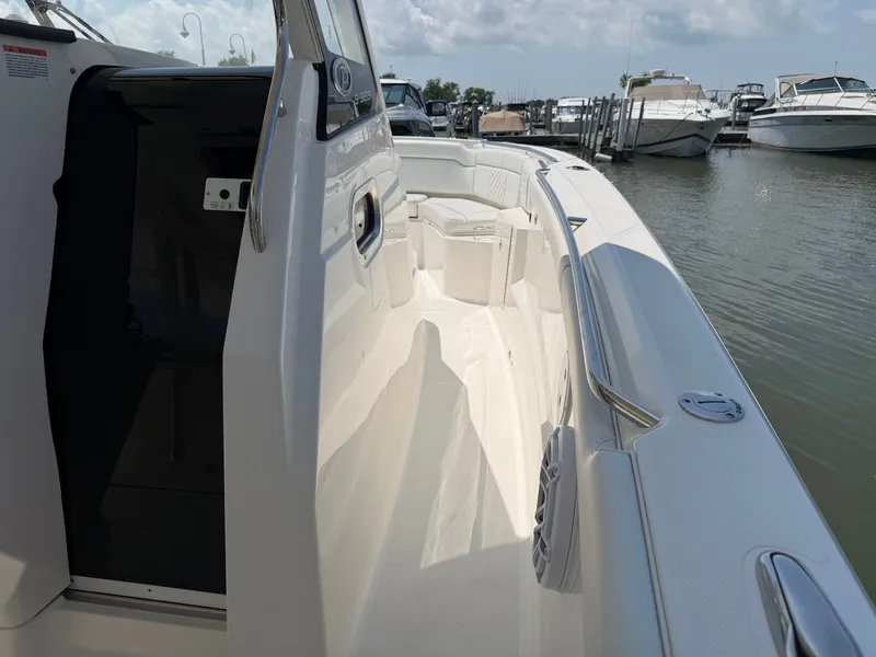 Slide: The Image of The image shows the deck of a 2025 Pursuit S 328 Sport boat docked at a marina. - 20