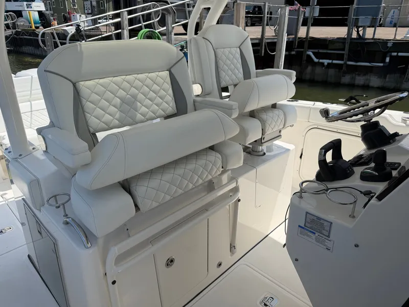 Slide: The Image of Two luxurious, quilted seats with diamond pattern on a boat, next to a modern helm station. - 18