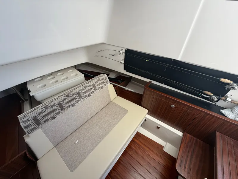 Slide: The Image of Interior of a 2025 Pursuit S 328 Sport with seating, fishing rods, and wooden flooring. - 33