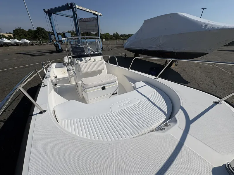 Slide: The Image of A 2011 Boston Whaler 170 Montauk is parked. It features an open deck and central console. - 2