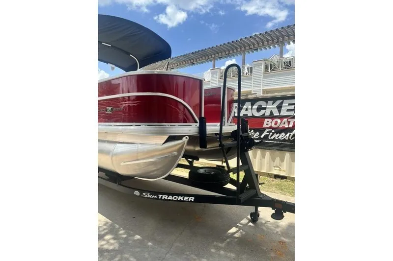 Slide: The Image of 2026 SUNTRACKER pb18 pontoon boat on trailer, red exterior, sunny day. - 13