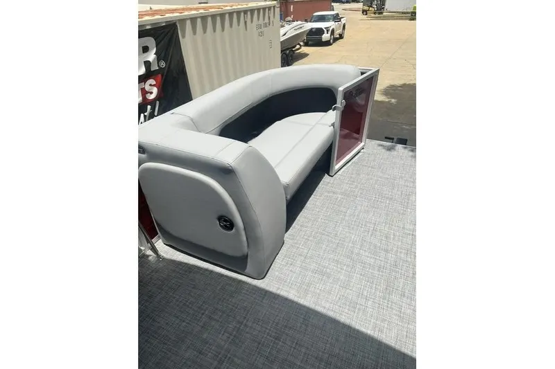 Slide: The Image of 2026 SUNTRACKER pb18 boat interior with gray seating and open storage compartment. - 10