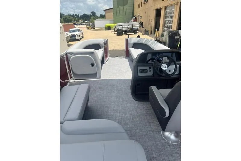 Slide: The Image of 2026 SUNTRACKER pb18 pontoon boat interior with gray seating and steering console. - 8