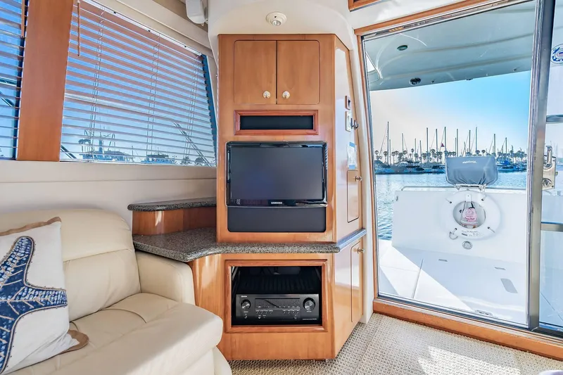Slide: The Image of Interior of 2000 Carver 450 Voyager Pilothouse with TV, sofa, and marina view. - 35