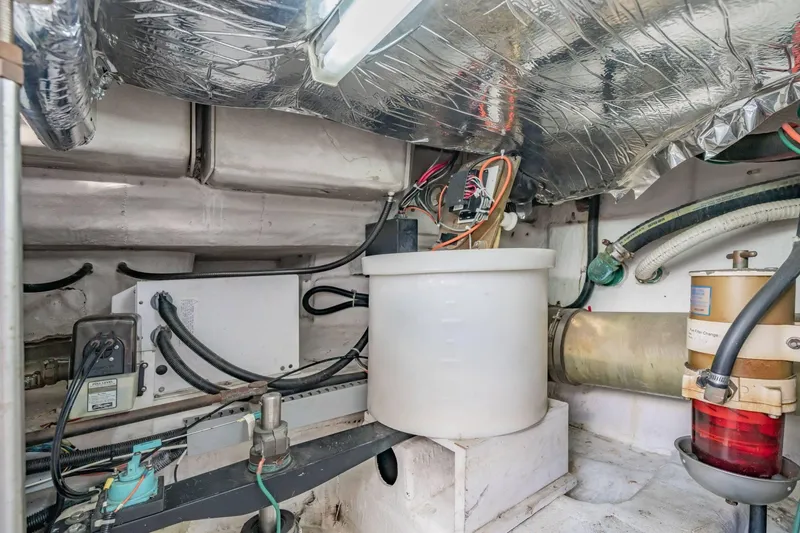 Slide: The Image of Engine room of 2000 Carver 450 Voyager Pilothouse with mechanical components and wiring. - 77
