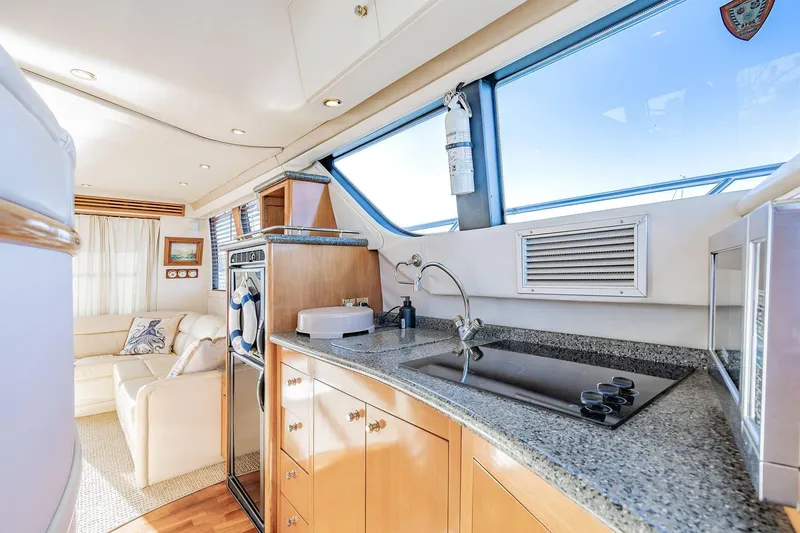 Slide: The Image of Luxurious interior of 2000 Carver 450 Voyager Pilothouse yacht with modern kitchen amenities. - 42