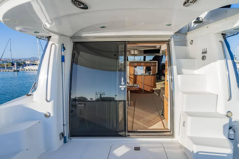Slide: The Image of 2000 Carver 450 Voyager Pilothouse yacht interior with open sliding door and marina view. - 16