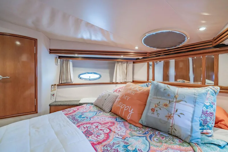 Slide: The Image of Luxurious bedroom interior of 2000 Carver 450 Voyager Pilothouse with colorful bedding and porthole window. - 57