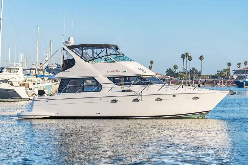 Slide: The Image of 2000 Carver 450 Voyager Pilothouse yacht docked in a sunny marina. - 7
