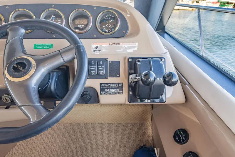 Slide: The Image of Pilothouse controls of a 2000 Carver 450 Voyager, featuring steering wheel and throttle levers. - 47