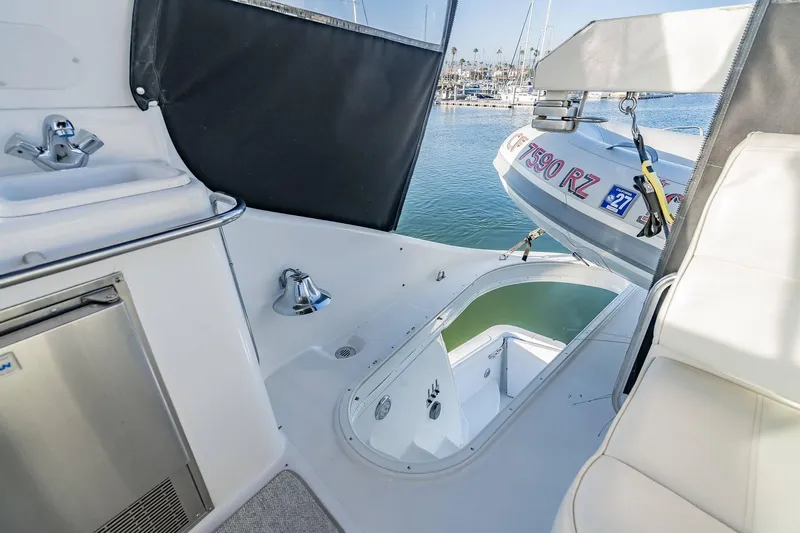 Slide: The Image of 2000 Carver 450 Voyager Pilothouse yacht deck with tender and marina view. - 23