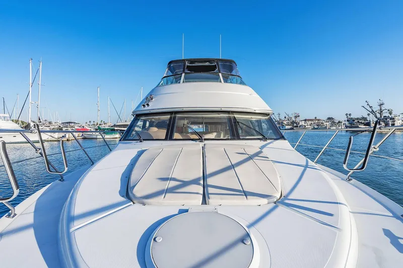 Slide: The Image of 2000 Carver 450 Voyager Pilothouse yacht docked in a marina under clear blue skies. - 20