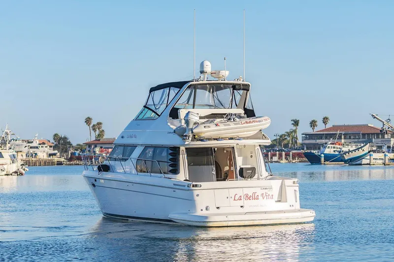 Slide: The Image of 2000 Carver 450 Voyager Pilothouse yacht docked in a sunny marina. - 3