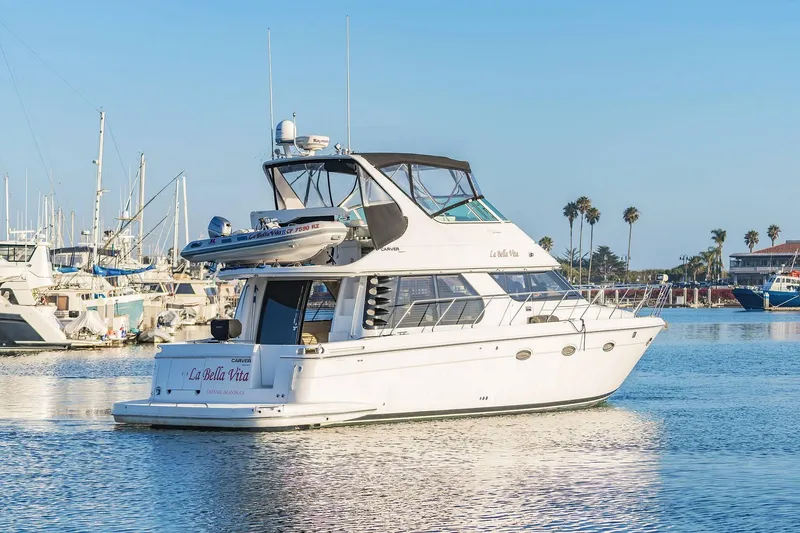 Slide: The Image of 2000 Carver 450 Voyager Pilothouse yacht docked in a sunny marina. - 6