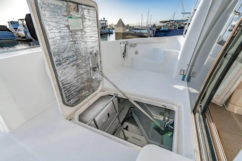 Slide: The Image of Open hatch on 2000 Carver 450 Voyager Pilothouse, revealing engine compartment at marina. - 69