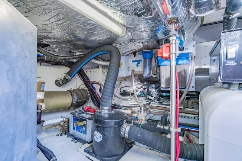 Slide: The Image of Engine room of 2000 Carver 450 Voyager Pilothouse with various mechanical components. - 76