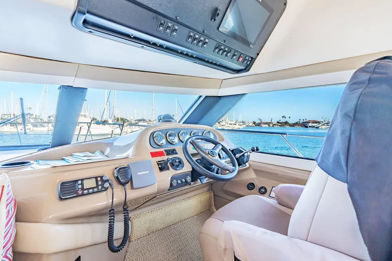 Slide: The Image of Interior view of 2000 Carver 450 Voyager Pilothouse helm with marina backdrop. - 43