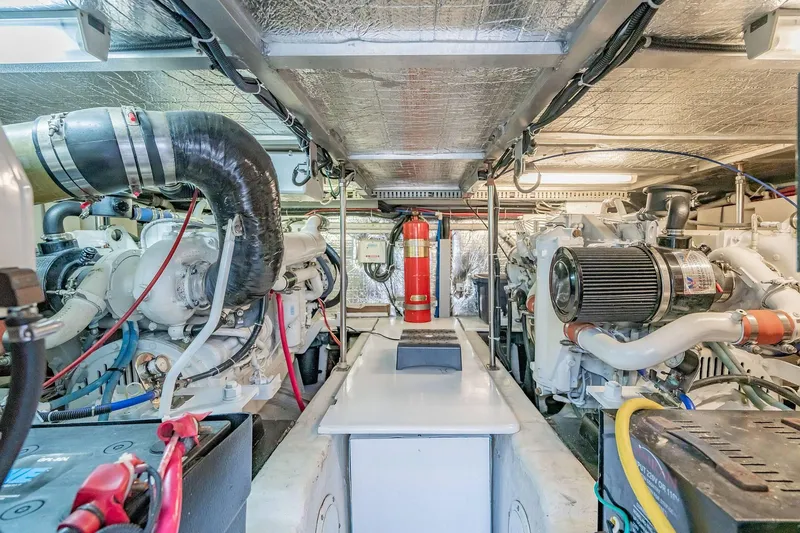 Slide: The Image of Engine room of 2000 Carver 450 Voyager Pilothouse with dual engines and fire extinguisher. - 70