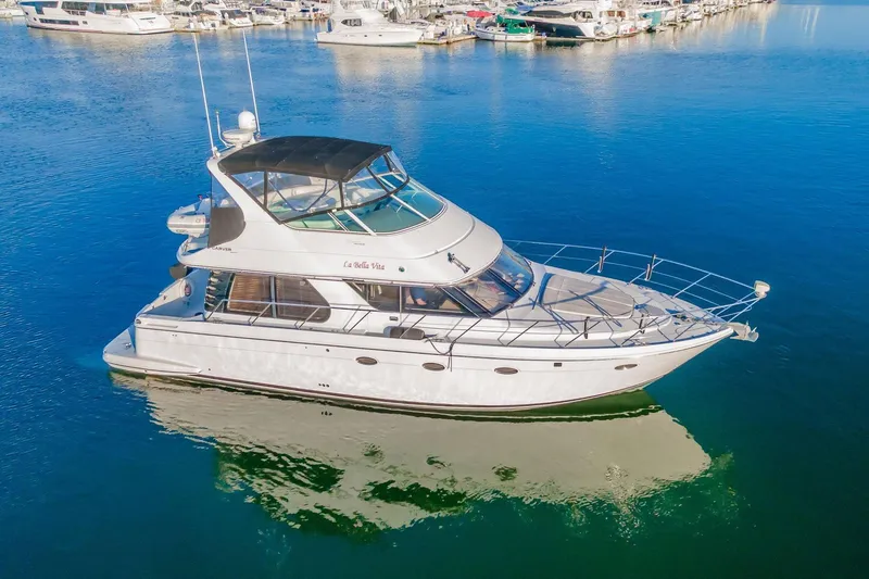 Slide: The Image of 2000 Carver 450 Voyager Pilothouse yacht docked in a serene marina setting. - 13