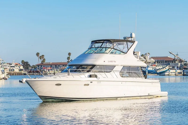 The Image of 2000 Carver 450 Voyager Pilothouse yacht docked in a sunny marina. - 0