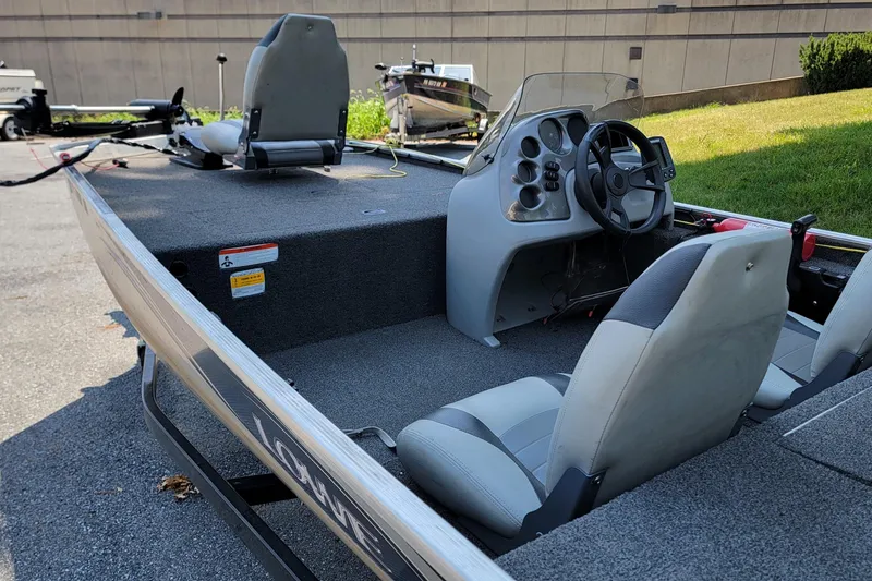 Slide: The Image of 2013 Lowe Skorpion boat interior with steering console and seating on a sunny day. - 4