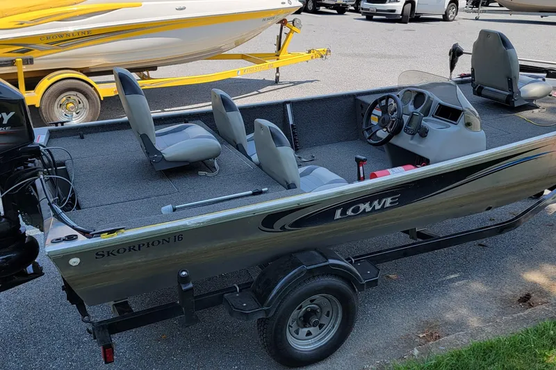Slide: The Image of 2013 Lowe Skorpion boat on trailer, featuring seating and steering console. - 9