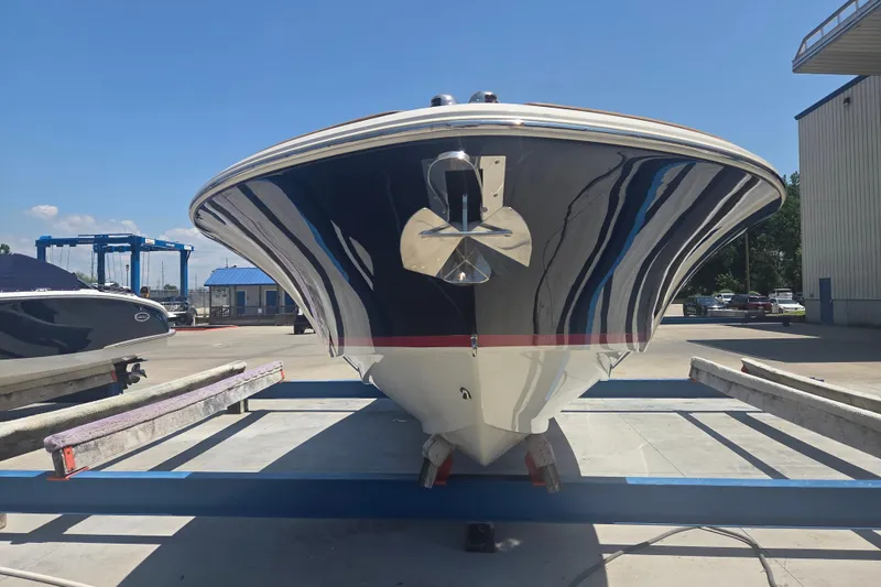 Slide: The Image of 2013 Chris-Craft Corsair 28 boat on trailer, viewed from the front in a marina setting. - 1