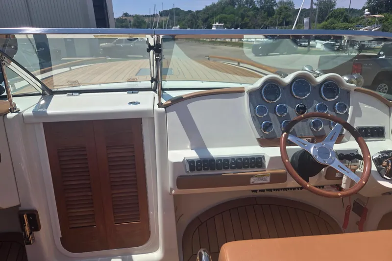 Slide: The Image of 2013 Chris-Craft Corsair 28 dashboard with classic wooden steering wheel and gauges. - 8