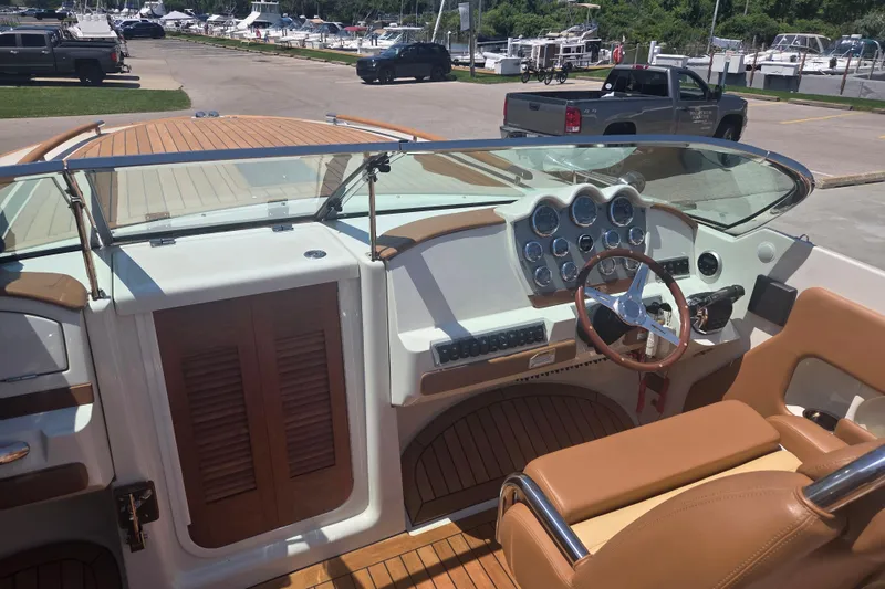 Slide: The Image of 2013 Chris-Craft Corsair 28 boat interior with wooden dashboard and leather seating. - 9