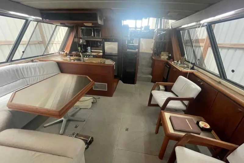 Slide: The Image of Interior of a 1988 Bayliner 4588 Pilothouse yacht with seating and kitchen area. - 4