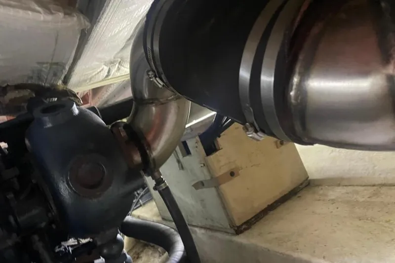 Slide: The Image of Engine compartment of a 1988 Bayliner 4588 Pilothouse, showcasing exhaust components. - 31
