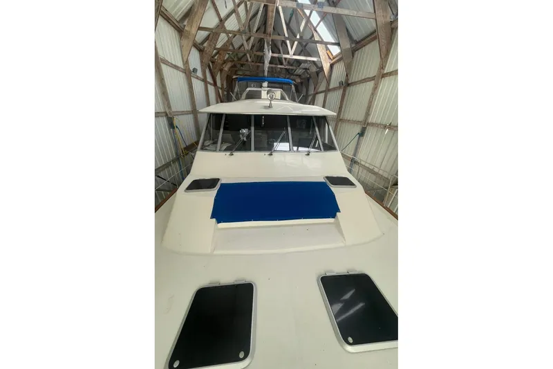 Slide: The Image of 1988 Bayliner 4588 Pilothouse yacht in a covered dock, showcasing its sleek design. - 26
