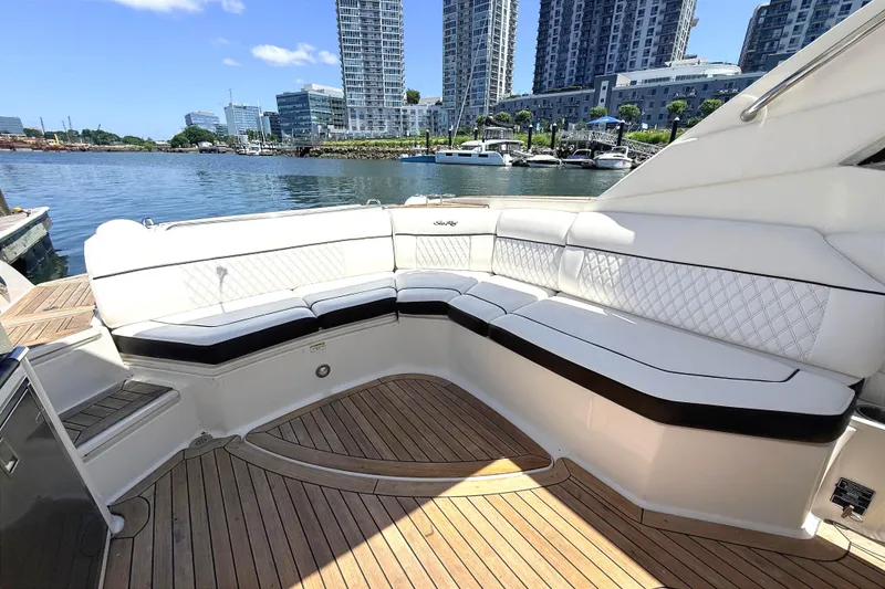 Slide: The Image of Luxurious seating on 2016 Sea Ray SLX 350 yacht, docked with city skyline backdrop. - 9